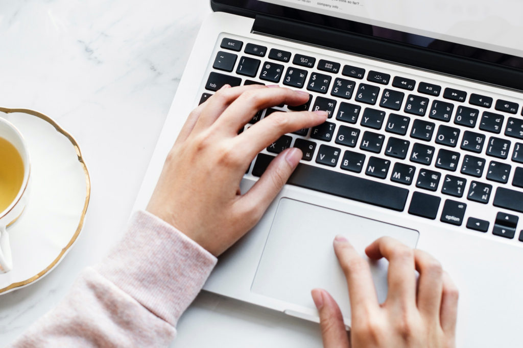 A woman typing on a laptop.