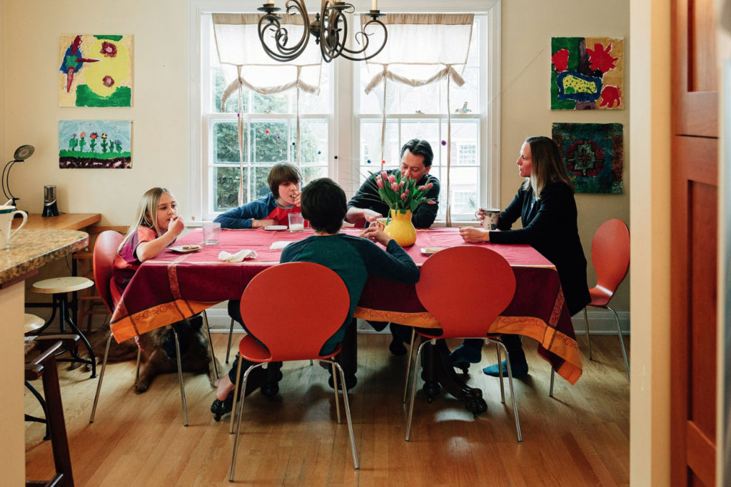 The Ferrazzano eats cookies at their dining room table.