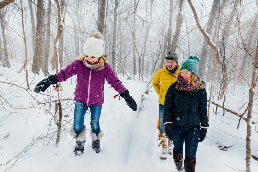 The Schwarzback-Katthreh family walks in the snowy woods.