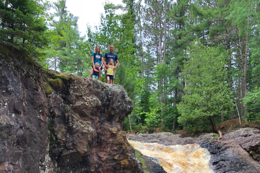 The Rohr family at the top of a cliff by waterfalls.