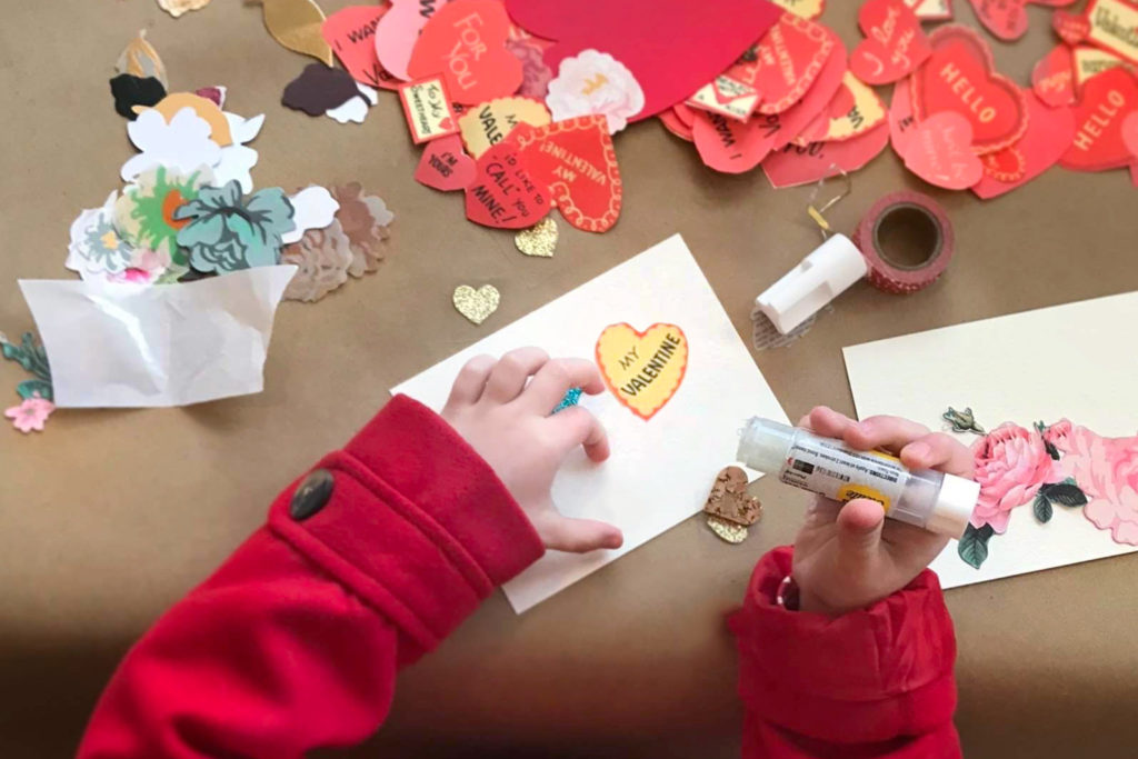 A girl making valentines.