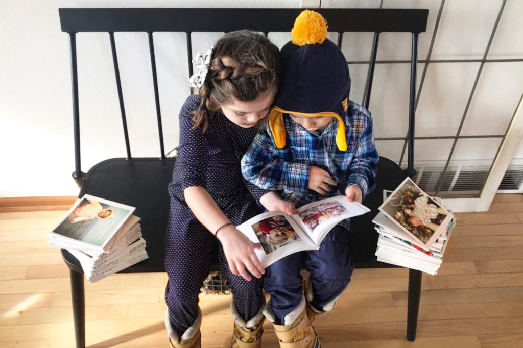 Two kids looking at photo books.