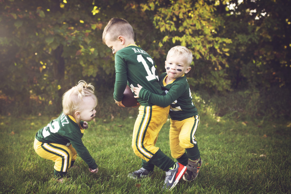 Kids playing football in Green Bay Packers uniforms.