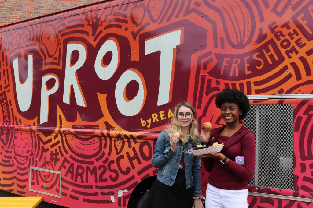 Two women outside the REAP Food Group food truck.