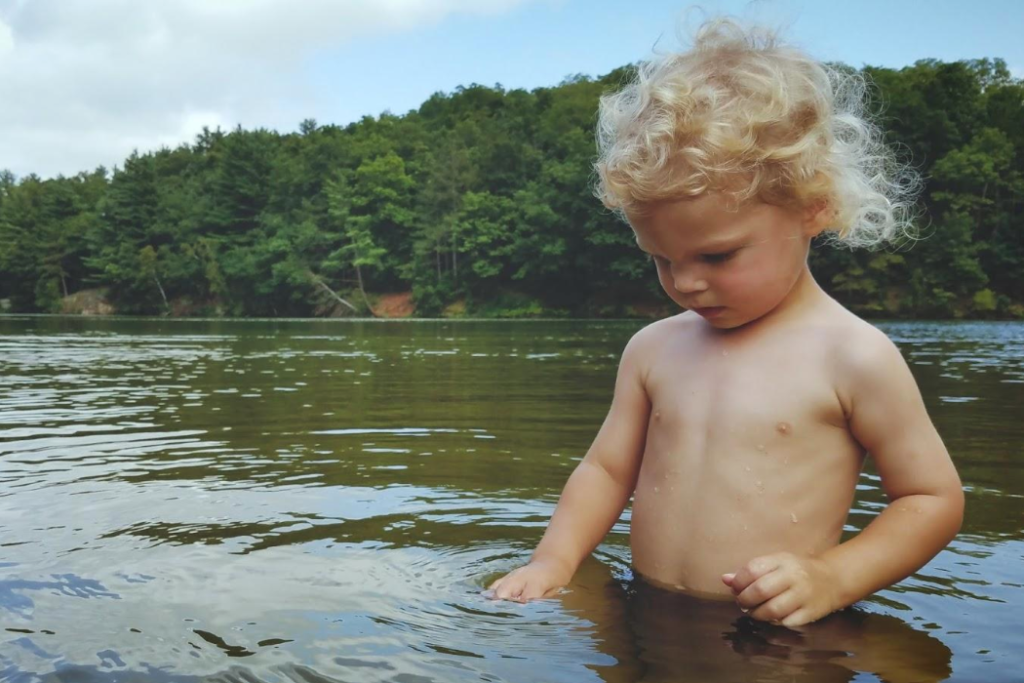 A boy wading in the lake at Stewart Lake County Park.