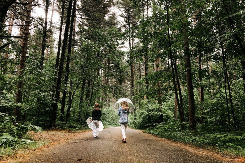 Two girls walk in a Wisconsin woods.