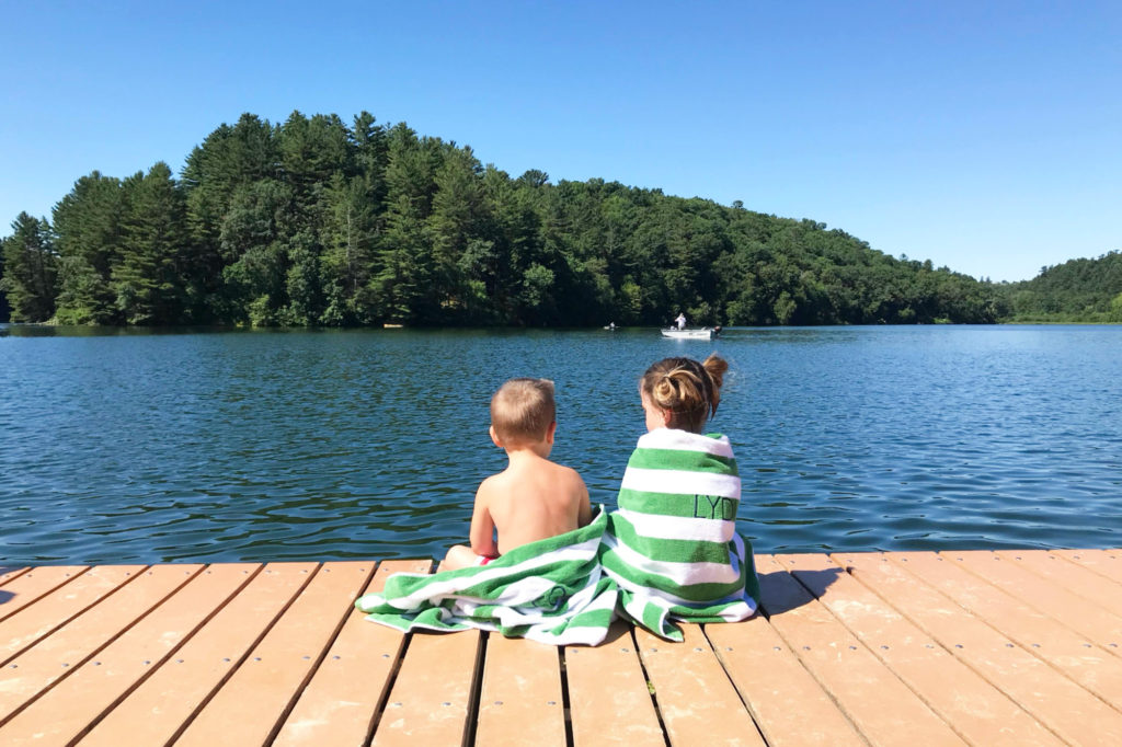 A brother and sister sit on a dock overlooking a Wisconsin lake.