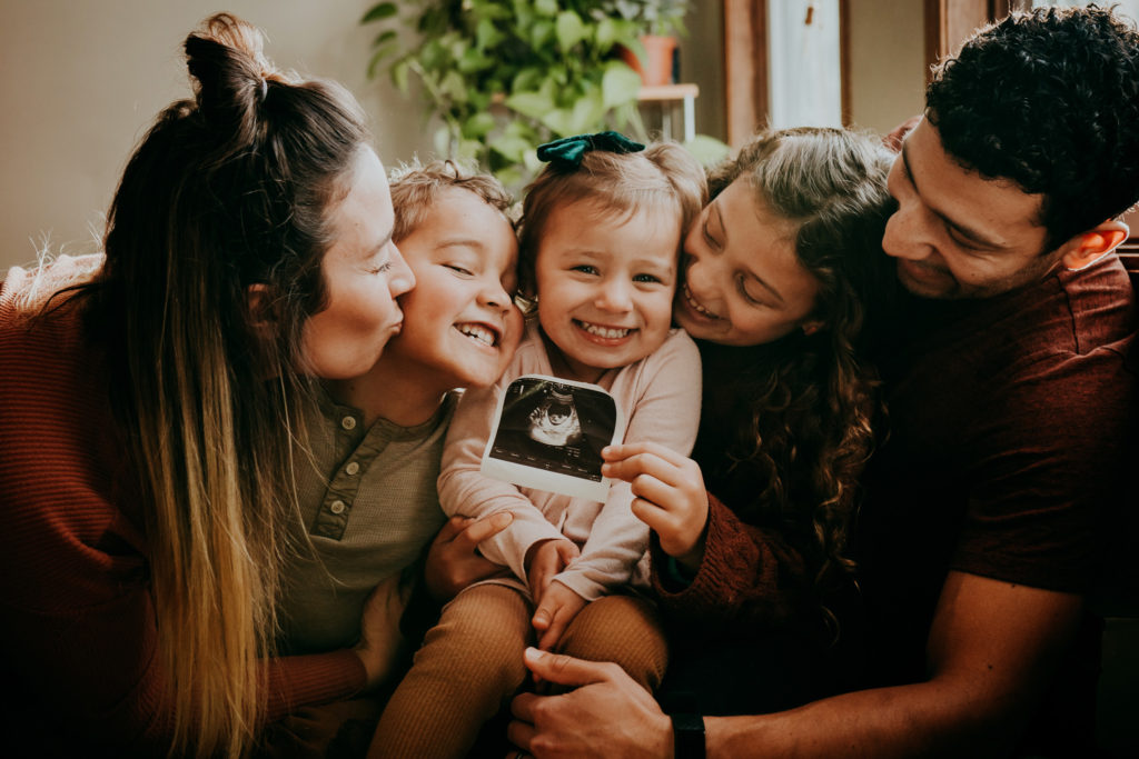 The Winters family holds an ultrasound photo of their new baby.