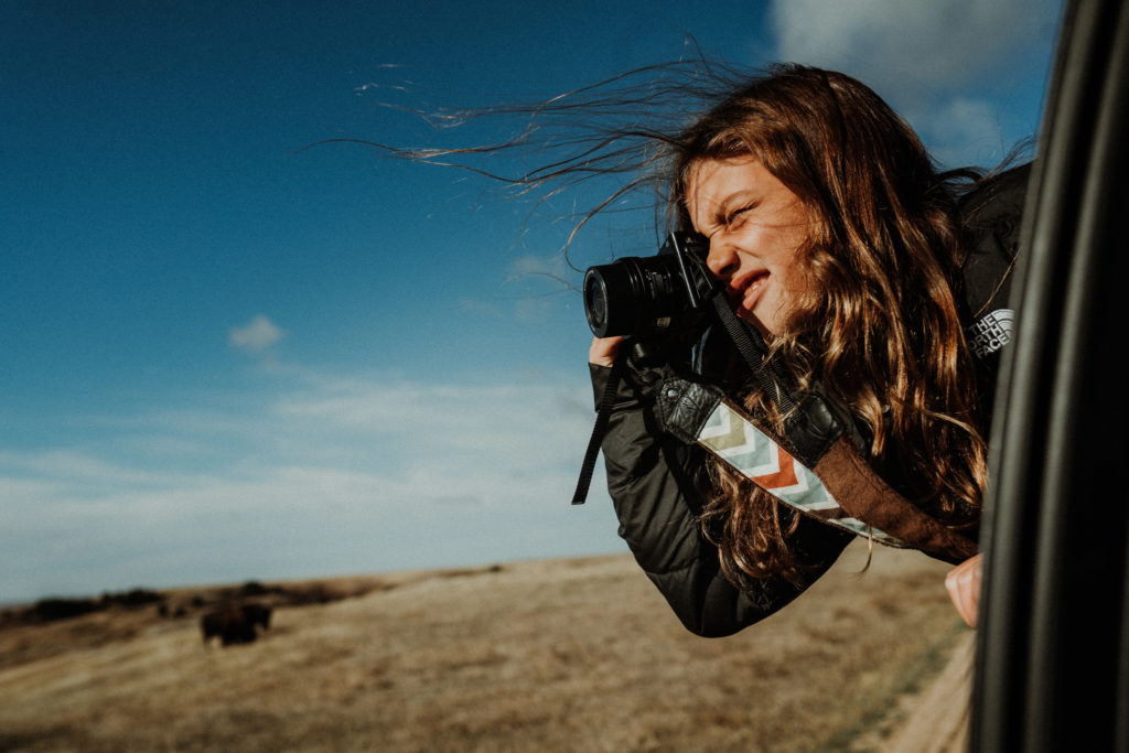 Ava Winters takes a photo leaning out of her family's car window.