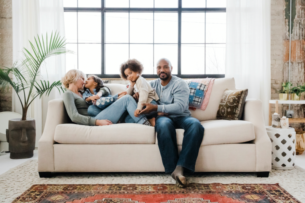 Amber and Fred Parham on a sofa with their two daughters. 