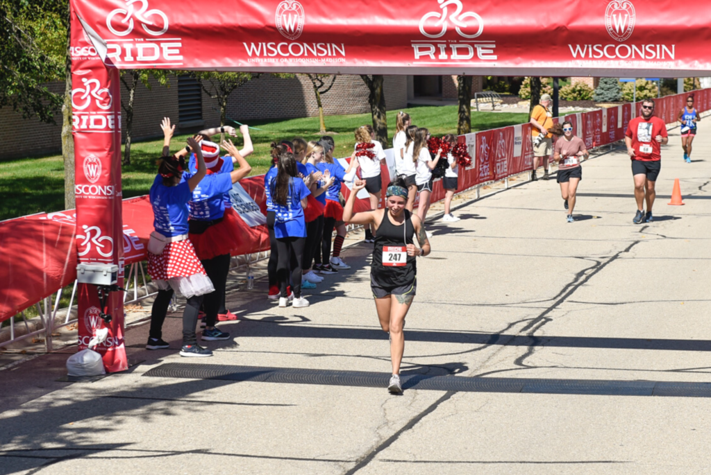 Lori Anderson crosses the finish line of a Wisconsin race with a fist in the air.