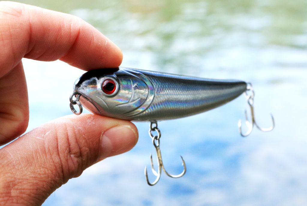 A man holds a fishing lure in his hand.