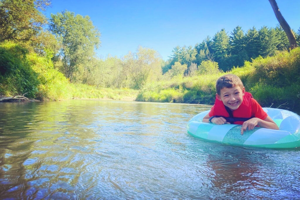 A boy floats on an inner tube on a calm river in Wisconsin.