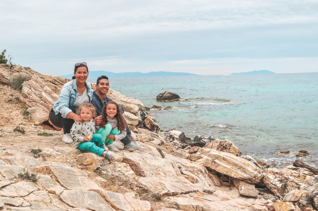 The Salas family sitting on a rocky shoreline. 