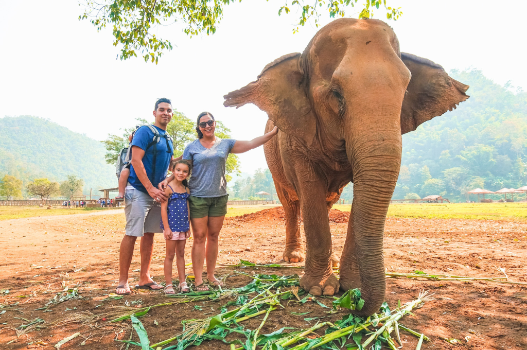 The Salas family standing by an elephant.